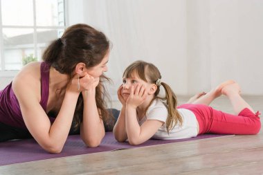genç anne ve kızı yoga egzersiz yaparak