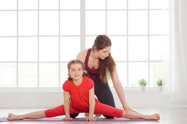 Młoda matka i córka robi ćwiczenia jogi — Zdjęcie stockowe