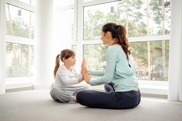 Giovane madre e figlia che fanno esercizio mattutino di yoga — Foto Stock