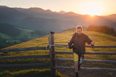 Hipster adam yola dağlarda günbatımı