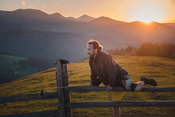 Хіпстер подорожує в горах на заході сонця — стокове фото