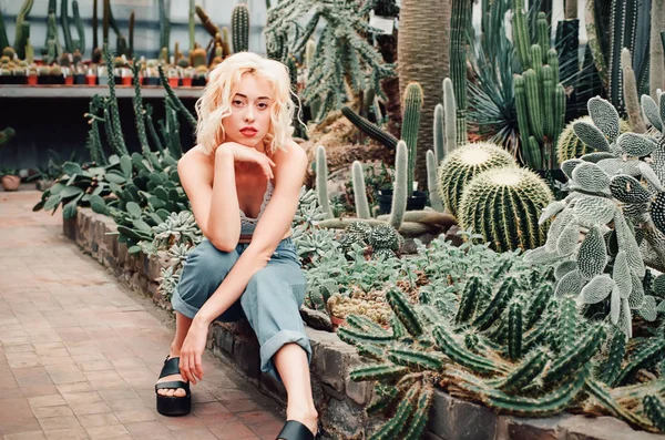 Beautiful blonde woman posing in tropical botanical garden — Stock Photo, Image