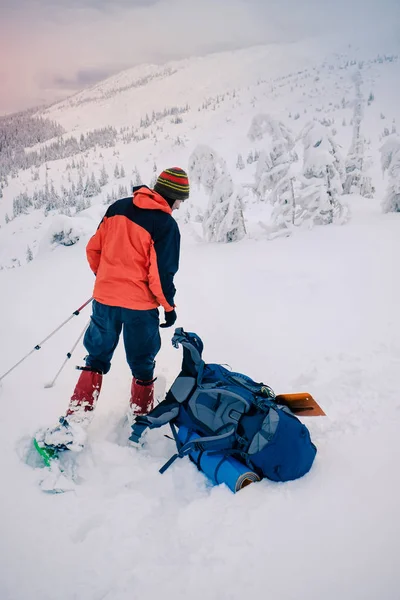 Senderismo de hombre con mochila y raquetas de nieve en hermosa montaña — Foto de Stock