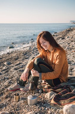 Genç kadın deniz Beach kahve pişirme