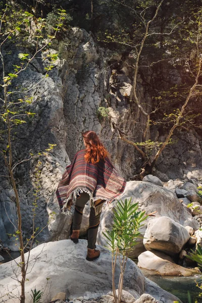 Женщина-путешественница в пончо стоит на скале в Турции — стоковое фото