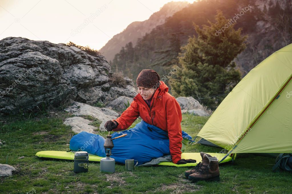 Female traveler cooking in the mountains