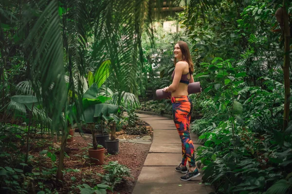 Positivo istruttrice di yoga femminile in posa in serra Immagine Stock