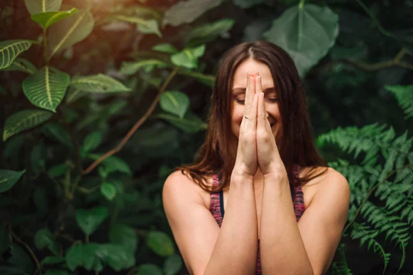 Jovem mulher meditando e fazendo exercício de ioga no parque tropical — Fotografia de Stock