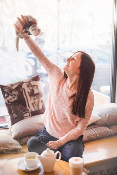 Ευτυχισμένος νεαρή γυναίκα δείχνει το κατοικίδιο κουνάβι σε καφετέρια — Φωτογραφία Αρχείου