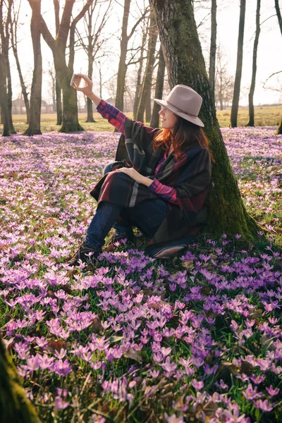 Våren krokusar i skogen och en kvinnlig resenär — Stockfoto