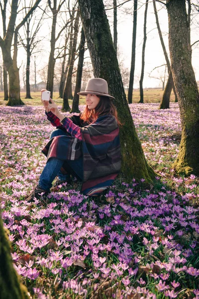 Våren krokusar i skogen och en kvinnlig resenär — Stockfoto