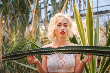 Baştan çıkarıcı beyaz kadın modeli ve kaktüsler, yeşillik