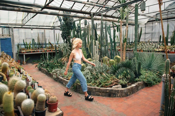 Modelo de moda femenina caminando entre plantas tropicales — Foto de Stock