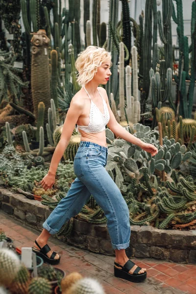 Slim perky female model walking confidently among succulents — Stock Photo, Image