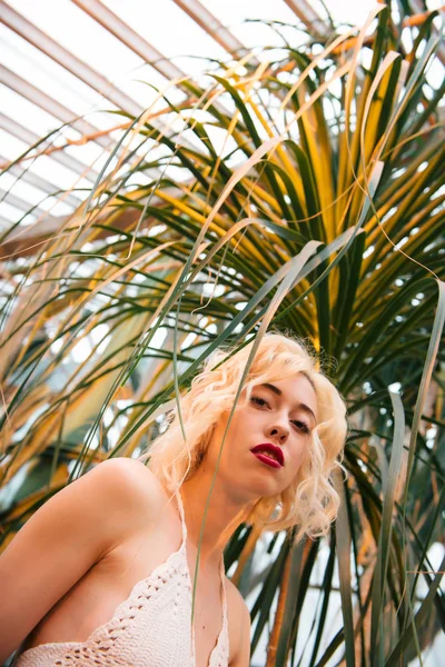 Bella modella femminile con occhi sognanti in posa al giardino botanico Foto Stock Royalty Free