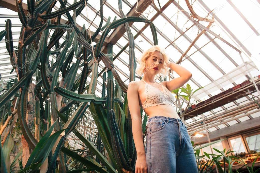 Fashion portrait of perky blonde model at greenhouse