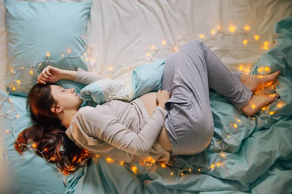 Mujer embarazada durmiendo en la cama — Foto de Stock