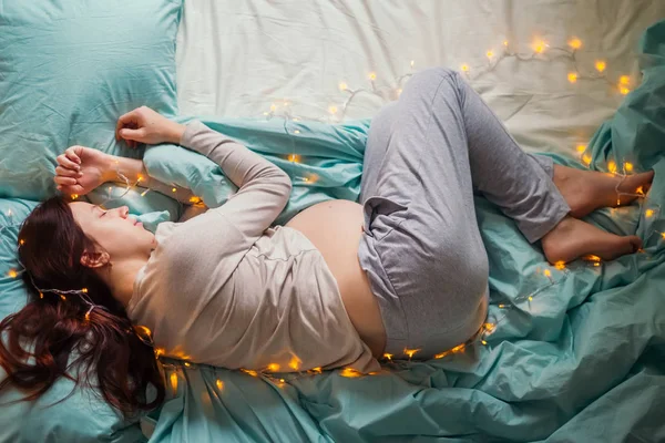 Mujer embarazada durmiendo en la cama — Foto de Stock