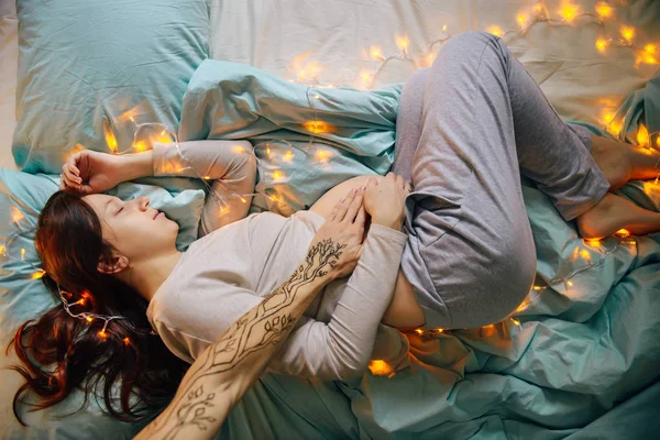 Těhotná žena spí na posteli — Stock fotografie