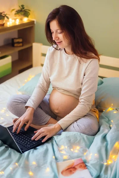 Aktywna Kobieta w ciąży działa na laptopie w łóżku — Zdjęcie stockowe