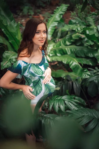 Atractiva pelirroja embarazada en un traje de baño floral en el gar tropical — Foto de Stock