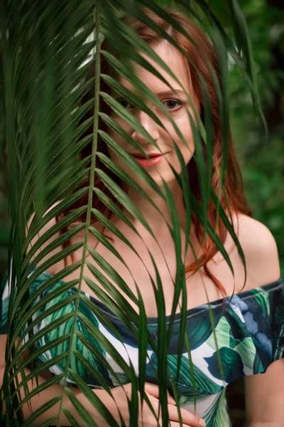 Belle jeune femme rousse caucasienne enceinte en feuilles de palmier — Photo