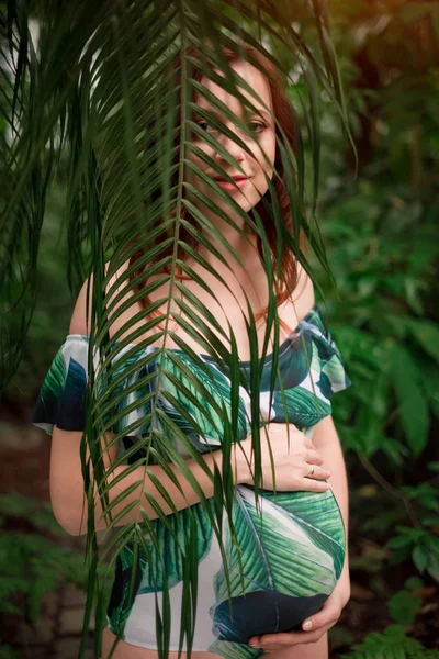 Hermosa embarazada caucásica pelirroja en traje de baño en palma l — Foto de Stock