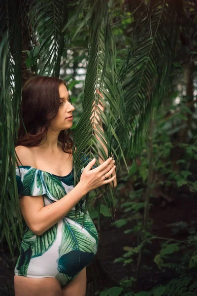 Junge schwangere kaukasische Rotschopf-Frau im Badeanzug in Palmenurlaub — Stockfoto