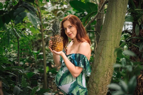 Mulher branca grávida sensual com um abacaxi em uma floresta — Fotografia de Stock