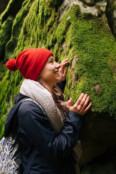 Happy female hiker touching green moss in forest — Stock Photo, Image