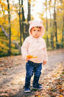 Bebeğim sonbahar orman parkında oynuyor.