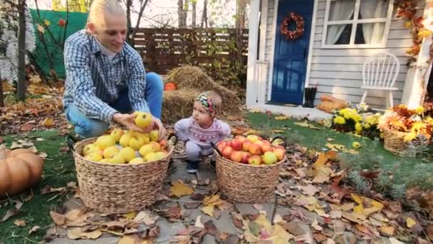 幸せな家族は家の農場の近くの秋の庭で遊んで楽しんでいます — ストック動画