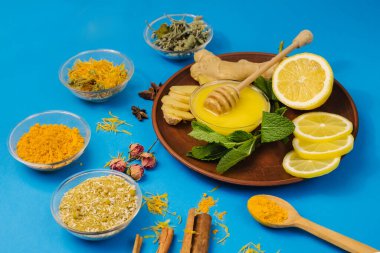 Alternatif ilaç tedavisi ve bağışıklık sistemi için limonlu ve ballı çay. Mavi arka planda doğal ürünler
