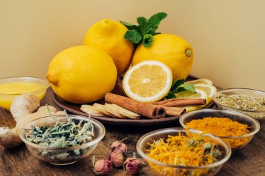 Daha iyi bağışıklık sistemi için limon ve ballı sağlıklı çay. Ahşap zemin üzerinde doğal ürünler