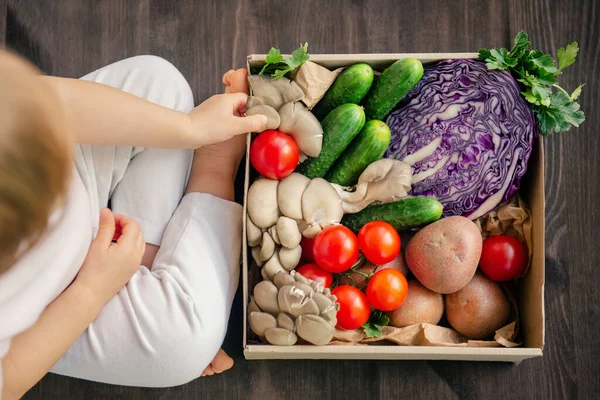 家族のための紙箱に新鮮で健康的な野菜を提供します 木の背景に健康的なベジタリアン料理のトップビュー — ストック写真