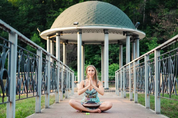 Femme assise près du parc et jouant sur un tambour heureux — Photo