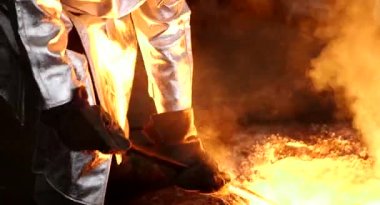 Dökümhanede sıkı çalışma. Erimiş çelik dökülüyor. Sıvı çelik dökülüyor. Erimiş metal dökümü, metalürji, çelik döküm dökümü. Çelik imalatı