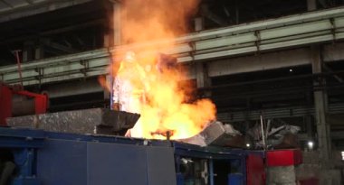 Dökümhanede sıkı çalışma. Erimiş çelik dökülüyor. Sıvı çelik dökülüyor. Erimiş metal dökümü, metalürji, çelik döküm dökümü. Çelik imalatı