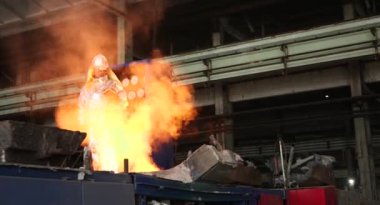 Dökümhanede sıkı çalışma. Erimiş çelik dökülüyor. Sıvı çelik dökülüyor. Erimiş metal dökümü, metalürji, çelik döküm dökümü. Çelik imalatı