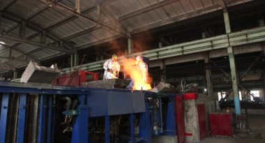 Dökümhanede sıkı çalışma. Erimiş çelik dökülüyor. Sıvı çelik dökülüyor. Erimiş metal dökümü, metalürji, çelik döküm dökümü. Çelik imalatı