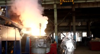 Dökümhanede sıkı çalışma. Erimiş çelik dökülüyor. Sıvı çelik dökülüyor. Erimiş metal dökümü, metalürji, çelik döküm dökümü. Çelik imalatı