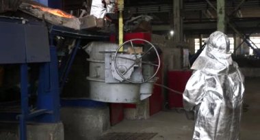 Dökümhanede sıkı çalışma. Erimiş çelik dökülüyor. Sıvı çelik dökülüyor. Erimiş metal dökümü, metalürji, çelik döküm dökümü. Çelik imalatı