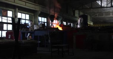 Dökümhanede çok çalışmak. Çelik fabrikasında metal eritme fırını. Erimiş metal dökümü, metalürji, çelik döküm dökümü. Çelik imalatı