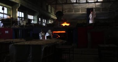 Dökümhanede çok çalışmak. Çelik fabrikasında metal eritme fırını. Erimiş metal dökümü, metalürji, çelik döküm dökümü. Çelik imalatı