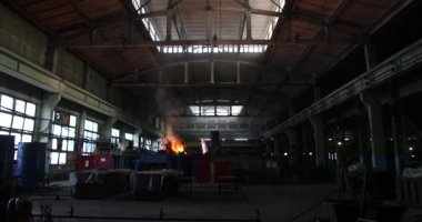 Dökümhanede çok çalışmak. Çelik fabrikasında metal eritme fırını. Erimiş metal dökümü, metalürji, çelik döküm dökümü. Çelik imalatı