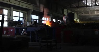 Dökümhanede çok çalışmak. Çelik fabrikasında metal eritme fırını. Erimiş metal dökümü, metalürji, çelik döküm dökümü. Çelik imalatı