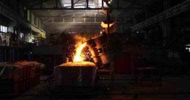 Dökümhanede çok çalışmak. Çelik fabrikasında metal eritme fırını. Erimiş metal dökümü, metalürji, çelik döküm dökümü. Çelik imalatı