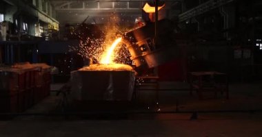 Dökümhanede çok çalışmak. Çelik fabrikasında metal eritme fırını. Erimiş metal dökümü, metalürji, çelik döküm dökümü. Çelik imalatı