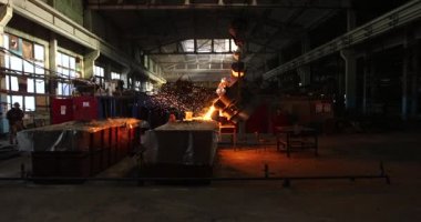 Dökümhanede çok çalışmak. Çelik fabrikasında metal eritme fırını. Erimiş metal dökümü, metalürji, çelik döküm dökümü. Çelik imalatı