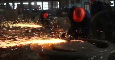 Erkek el nargile parçaları açısı öğütücü ile keser. Bir çelik inşaat alanında kıvılcım sıçraması ile kesme. Metal açılı taşlama kesim sırasında kıvılcım
